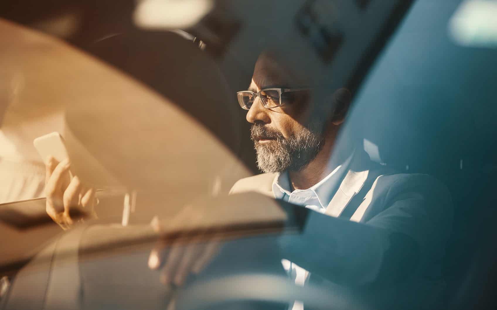 Mann mit Handy im Auto