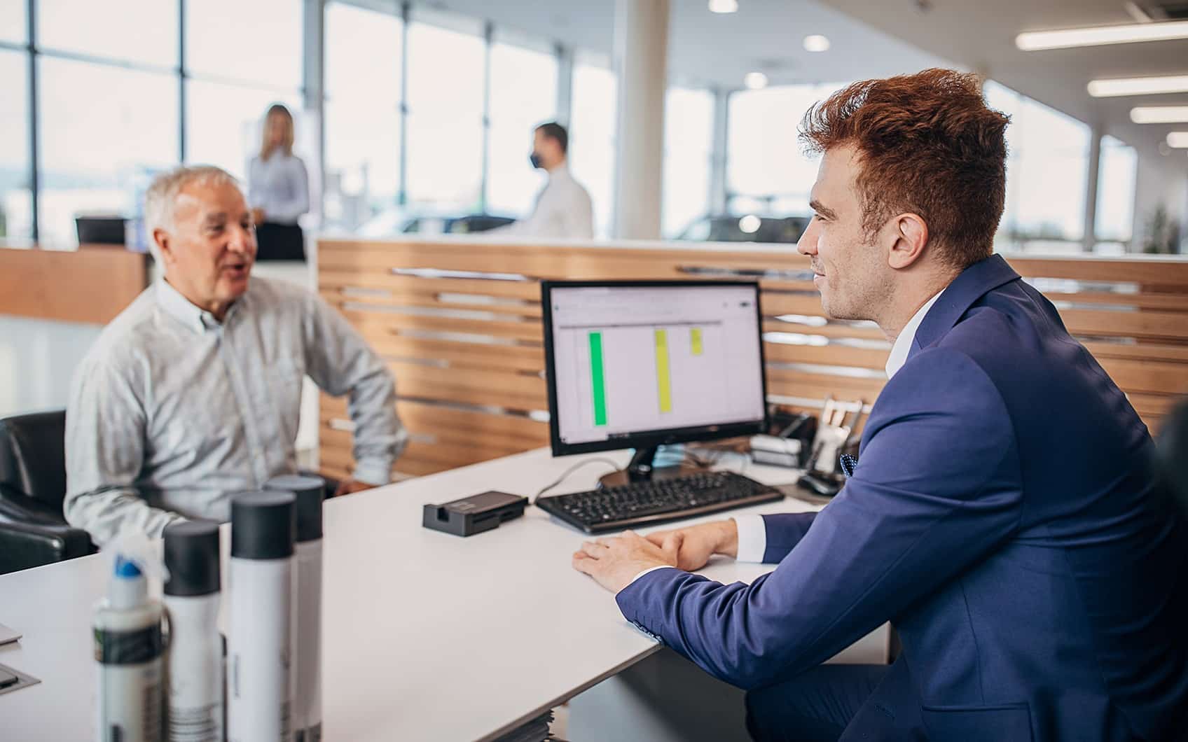 bmw-verkaeufer-in-autohaus-schreibtisch-mit-kunde-teaser