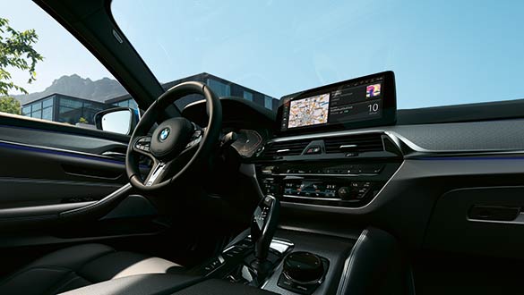 BMW 5er Touring PHEV Innenraum mit Fokus auf Lenkrad und Infotainment-Display