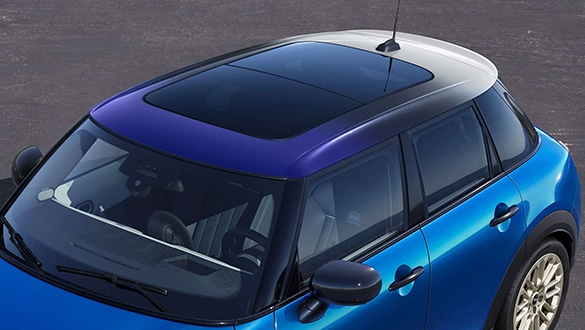 Vogelperspektive auf einen MINI 5-Türer in der Farbe Blau mit Panorama Glasdach