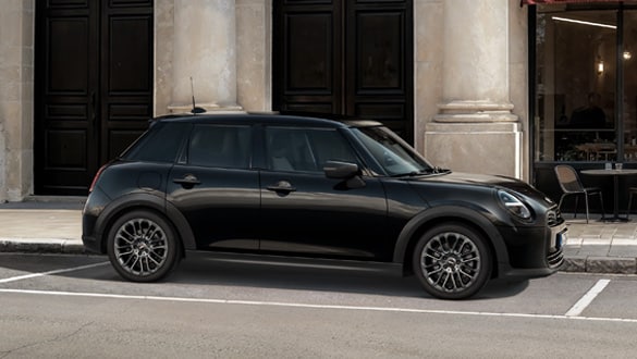 Seitenansicht eines MINI Cooper 5-Türer Blackyard parkend vor einem historischen Gebäude mit Säulen und dunklen Türen