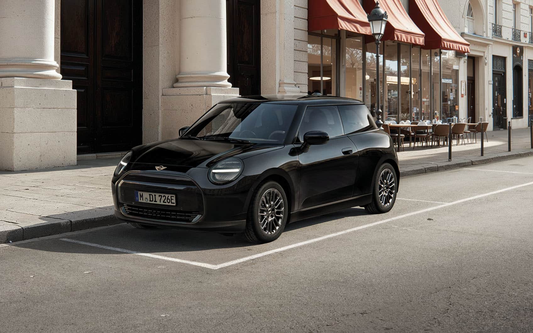 MINI Cooper Electric Blackyard parkt am Straßenrand vor mondäner Stadtlandschaft