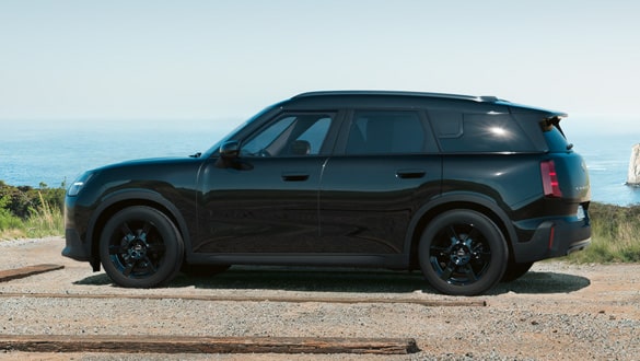 Seitenansicht eines MINI Countryman Blackyard auf einem Küstenweg mit Meer im Hintergrund