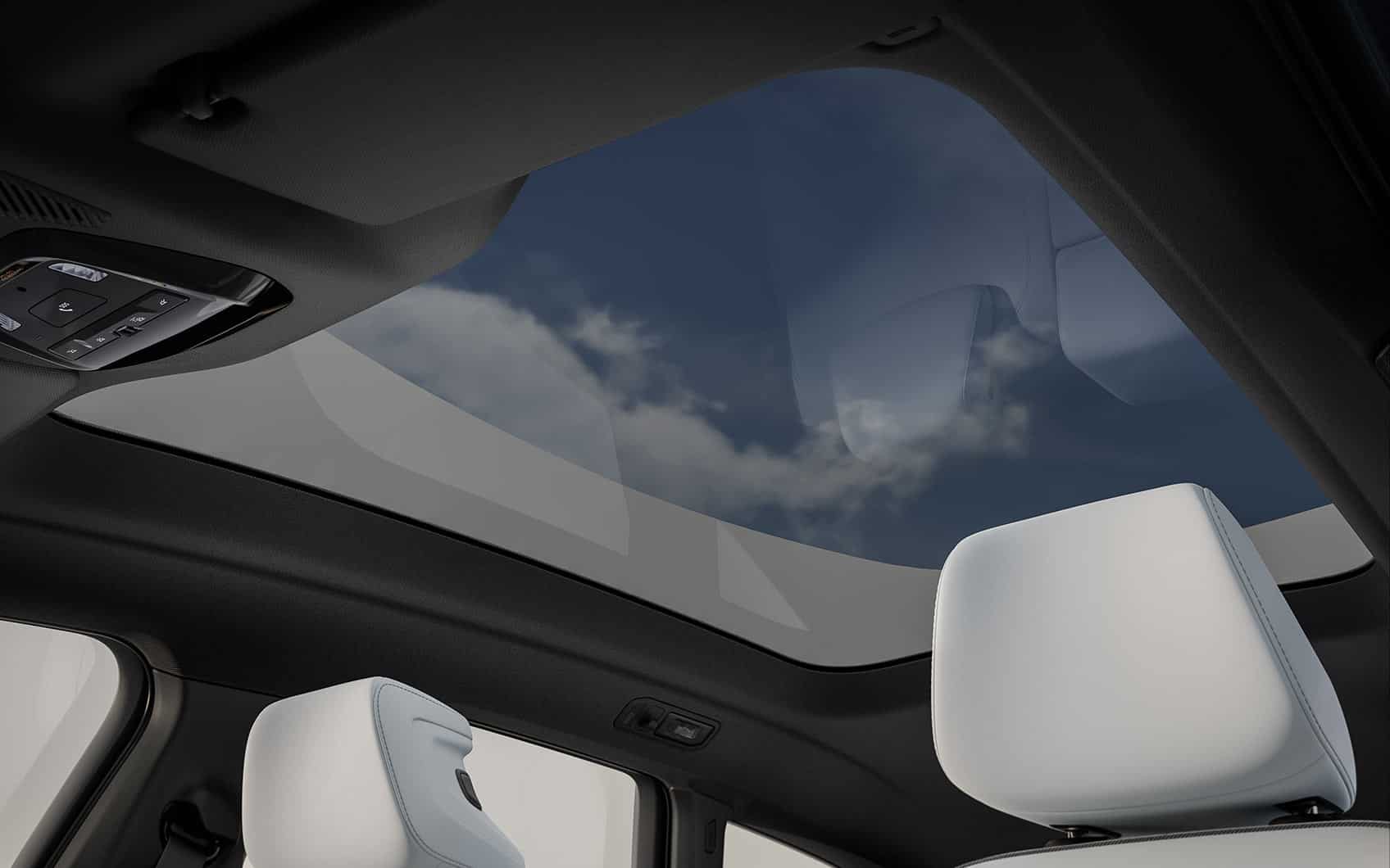 Blick durch das Panoramadach des BMW iX3 mit teilweise sichtbaren Kopfstützen und Bedienelementen.