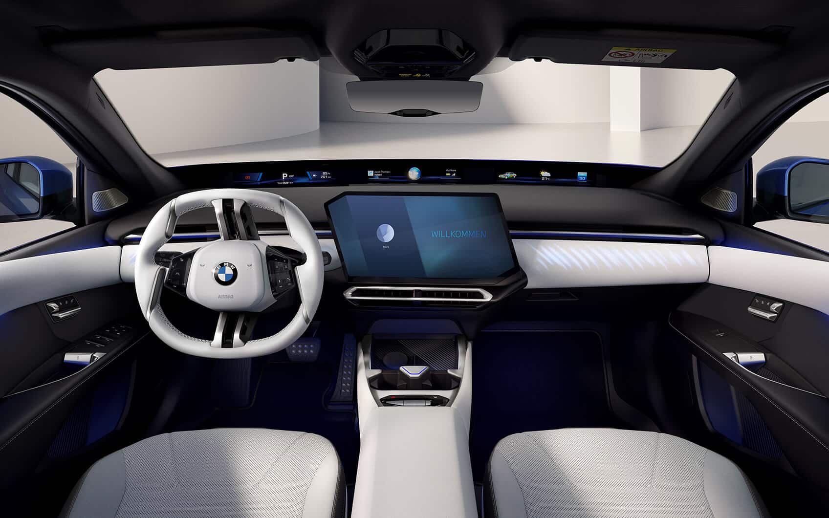 Innenraum des BMW i3 mit weißem Lenkrad, Panoramadisplay und zentralem Touchscreen